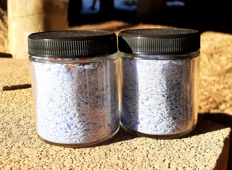 Two glass jars, each filled with pale blue bath salts.