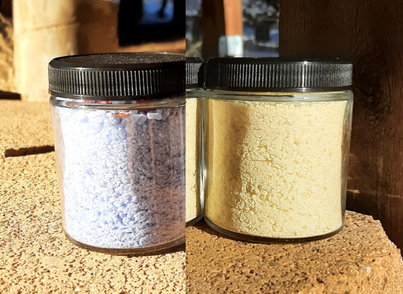 Two glass jars, each filled with bath salts, one pale blue, one pale yellow.