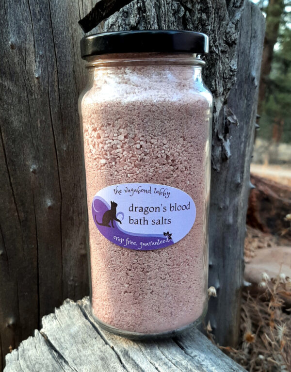 A clear glass jar filled with reddish-brown bath salts.