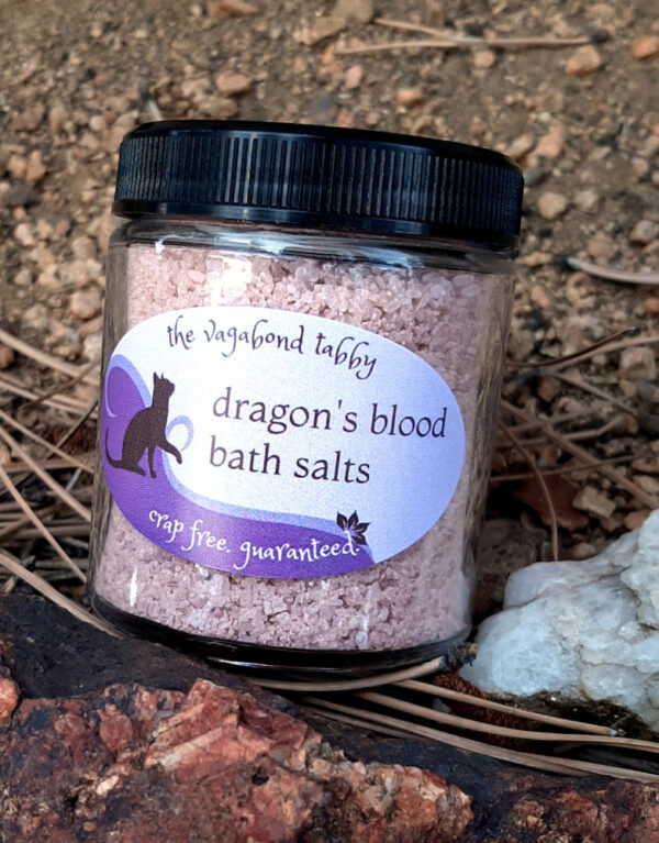 A clear glass jar filled with reddish-brown bath salts.