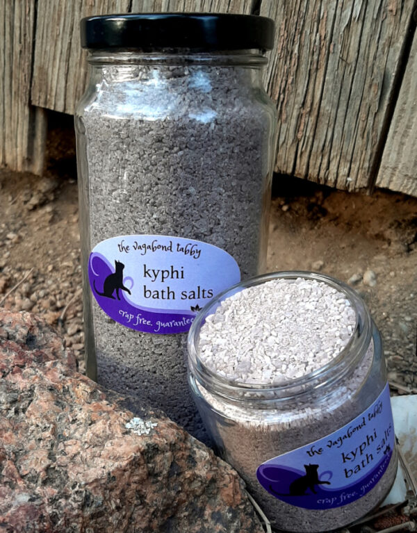 Two clear glass jars, each filled with brown bath salts; one is much taller than the other.