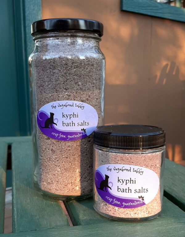 Two clear glass jars, each filled with brown bath salts; one is much taller than the other.