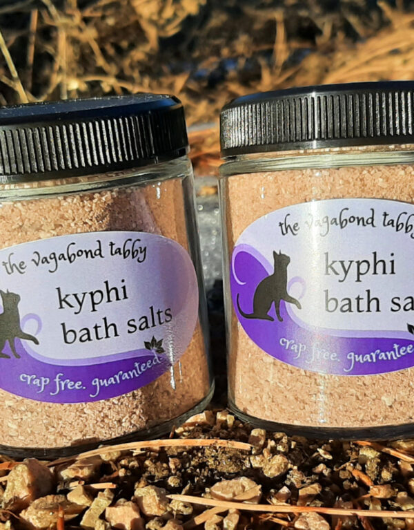 Two clear glass jars, each filled with brown bath salts.