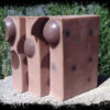 Three bars of soap, medium brown with darker brown spheres embedded within.