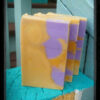 Three bars of soap, yellow with purple spheres and cubes embedded within.