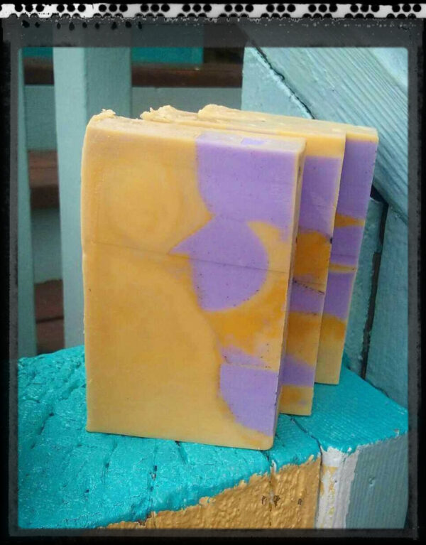 Three bars of soap, yellow with purple spheres and cubes embedded within.