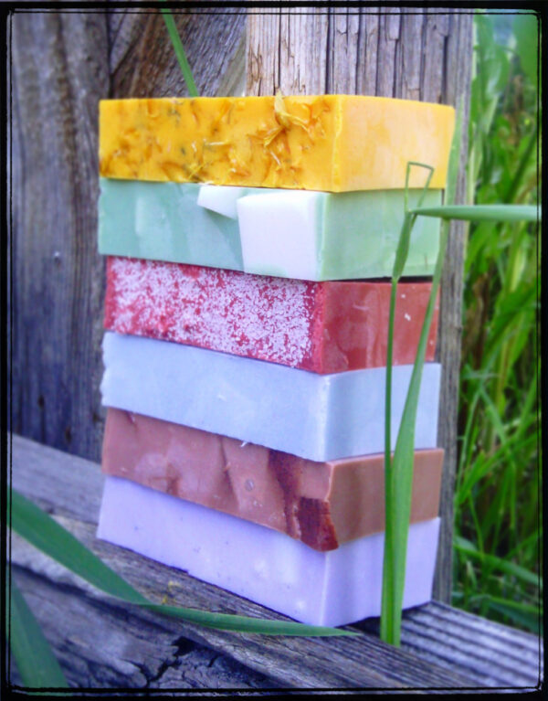 A stack of soap in various colors -- yellow, green, red, pale blue, brown, and purple.