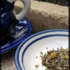 A blue and white saucer holds a scattering of tea; next to it sits a matching blue teacup.