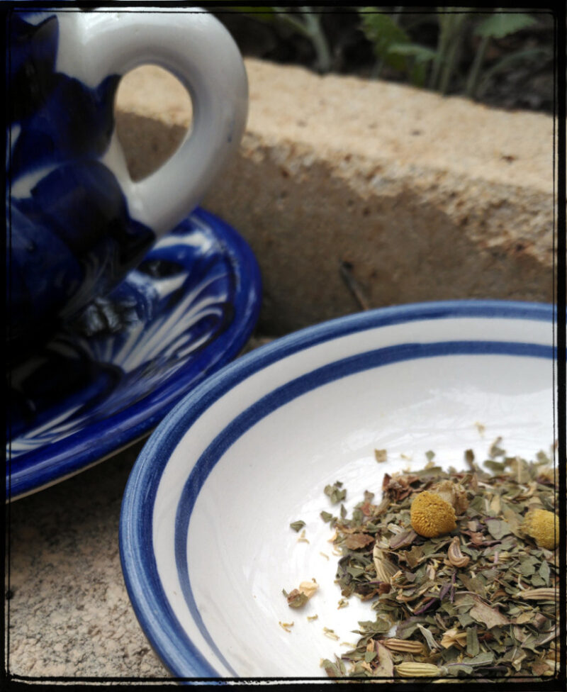 A blue and white saucer holds a scattering of tea; next to it sits a matching blue teacup.