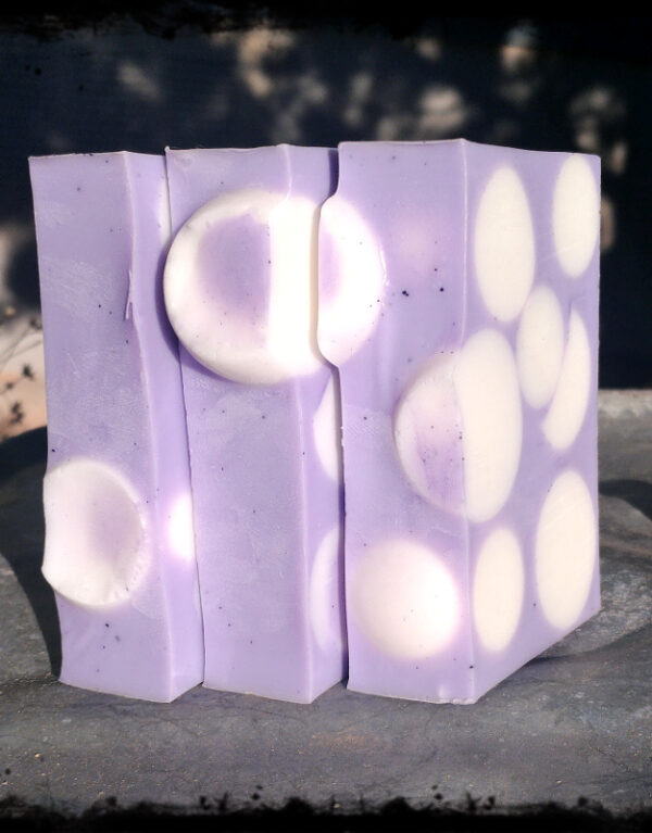 Three bars of soap, purple with white spheres.