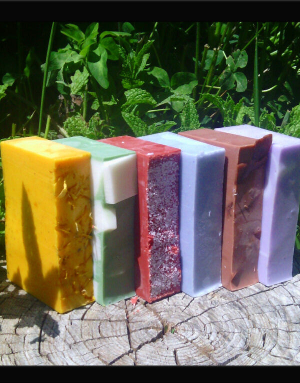 A stack of soap in various colors -- yellow, green, red, pale blue, brown, and purple.