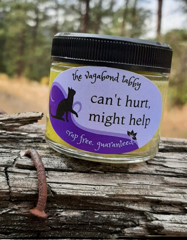 A clear glass jar of pale yellow salve.