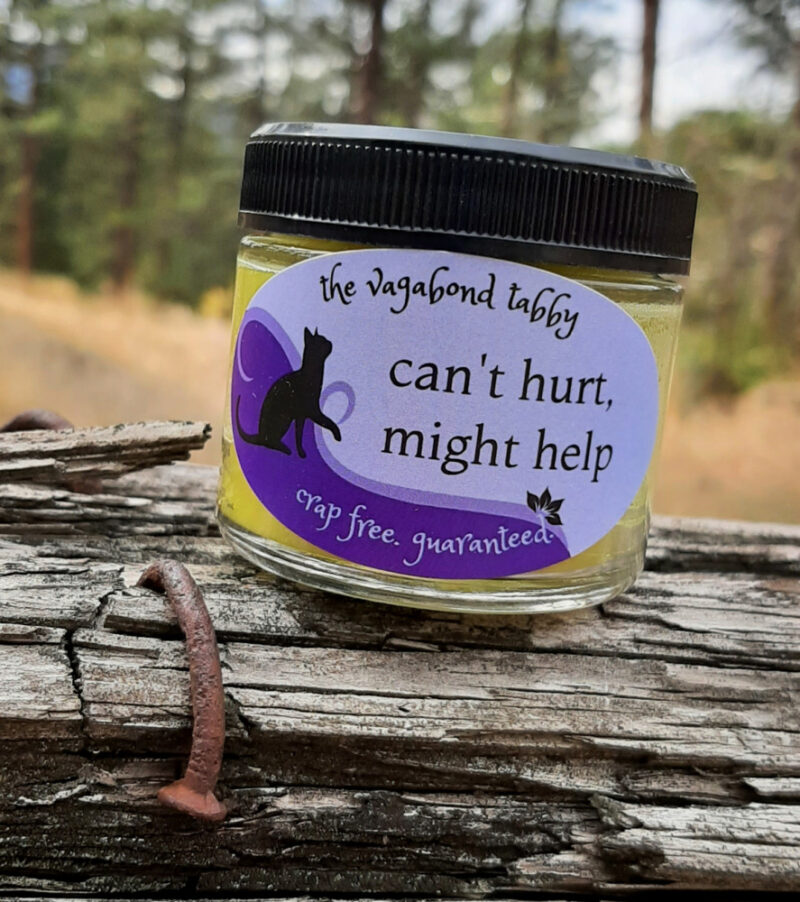 A clear glass jar of pale yellow salve.