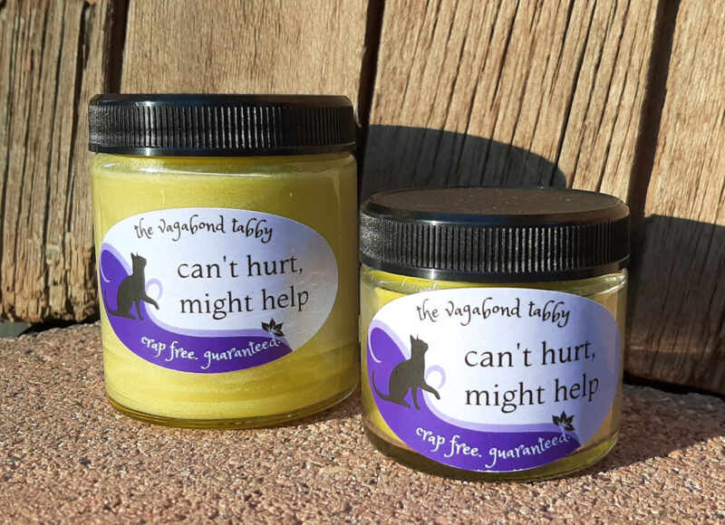 Two clear glass jars of pale yellow salve, one bigger than the other.