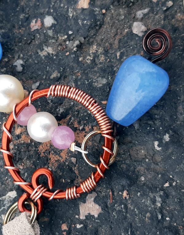 A close view of the bright copper loop at the top; it's good thick wire, shaped into a loop and hammered flat. The narrower copper wire is wrapped around it in decorative spirals.