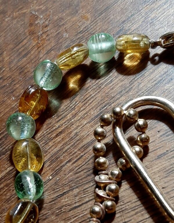 A closer view of the glass beads. The pale green ones are round; the amber-colored ones are slightly flattened ovals.