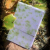 A single bar of soap, purple speckled with green herbs.