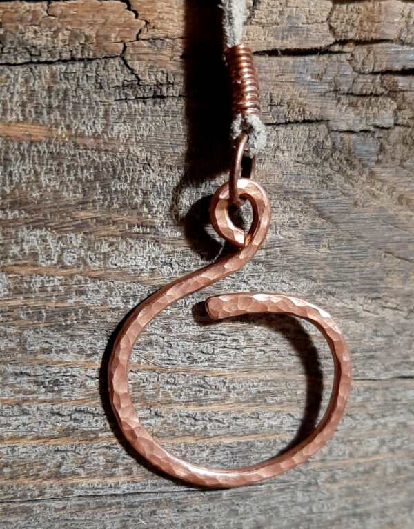 This pendulum features a squiggly pointer on one end and an oval finger loop on the other, both of hammered copper wire, with strung blue and white beads and a length of off-white leather thong in between.