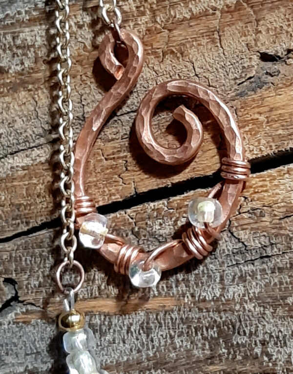 Lovely deep orangey-brown beads set off by lil glass beads that are MOSTLY clear but have just a tint of yellow, plus a pointer & finger loop of hammered copper wire.