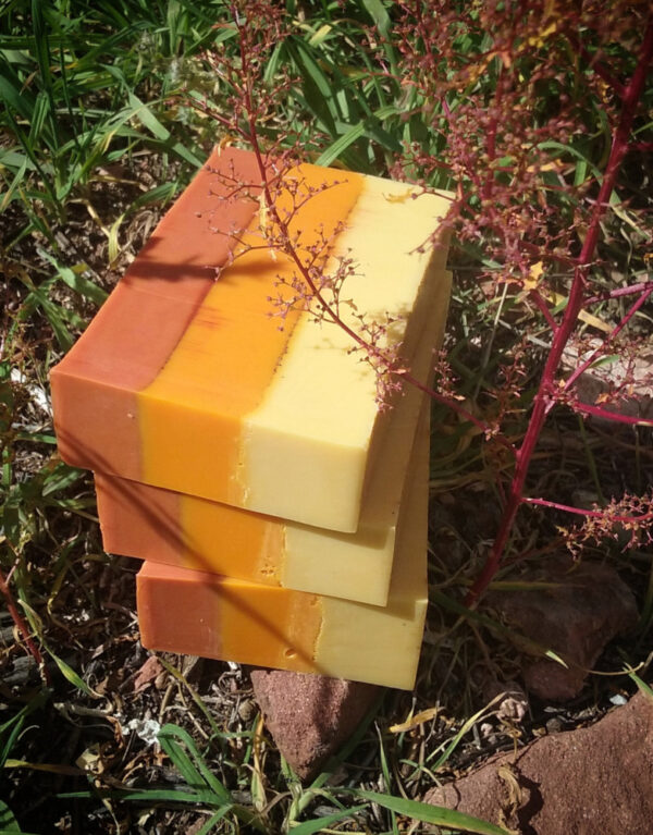 Three bars of soap, layered in yellow, orange, and red.