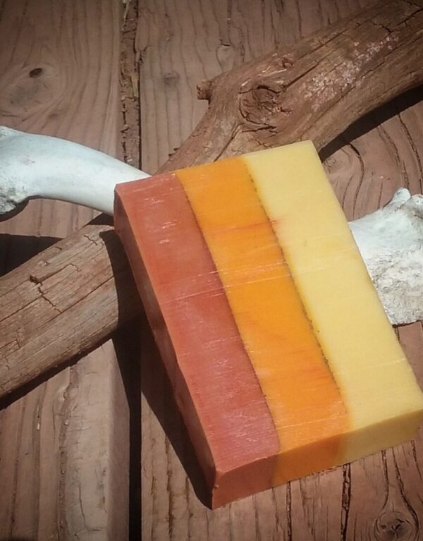 A bar of soap, layered in yellow, orange, and red.