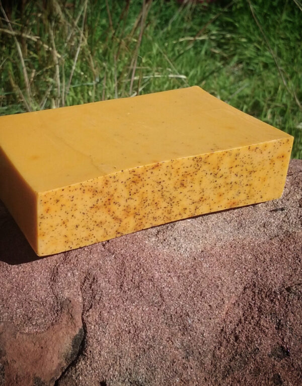 A bar of lightly speckled orange soap.