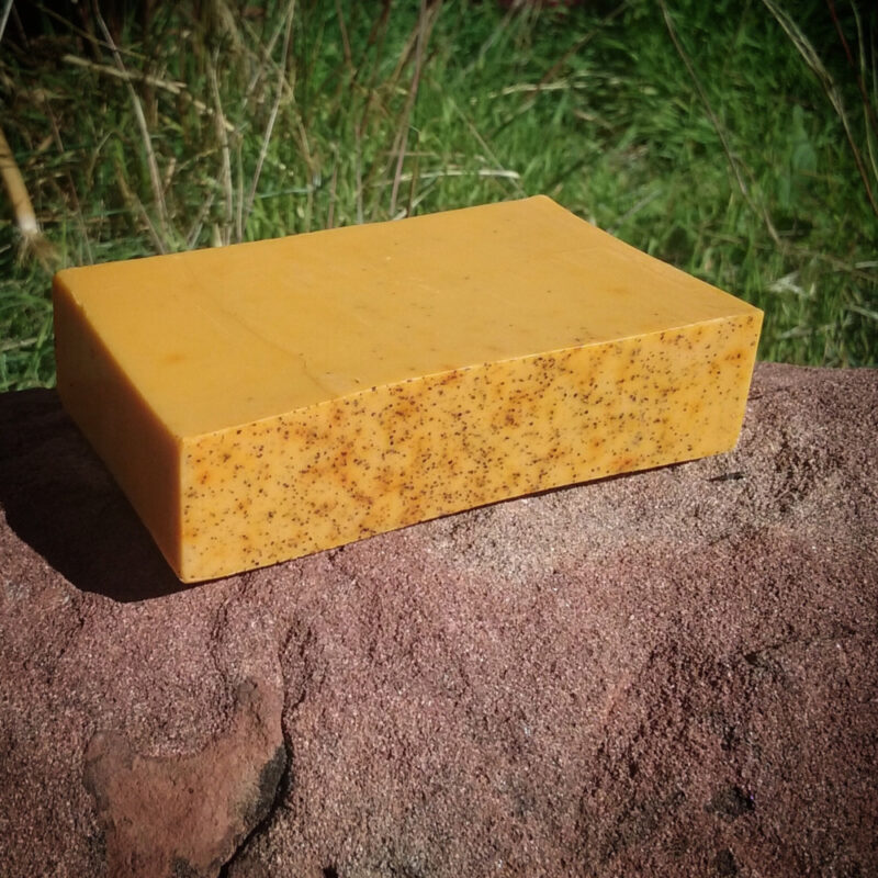 A bar of lightly speckled orange soap.